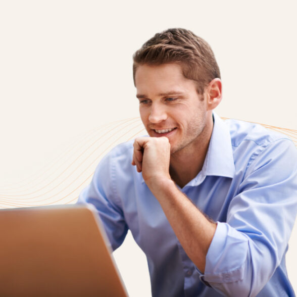 A seated man looking at a laptop screen.