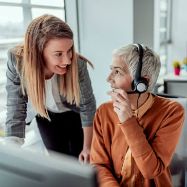 Two workers consulting in front of a laptop.