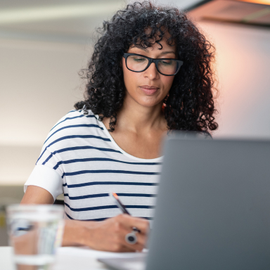 A seated woman working in front of her laptop.