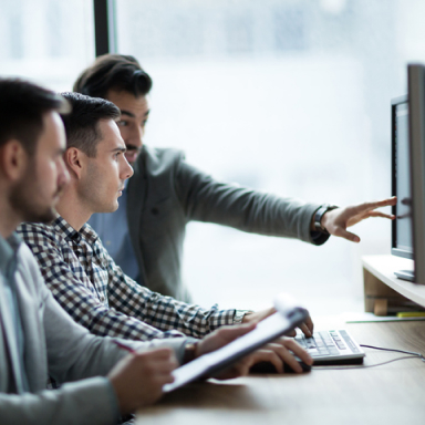 Three people looking a computer screen.