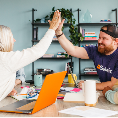 Two people high fiving.