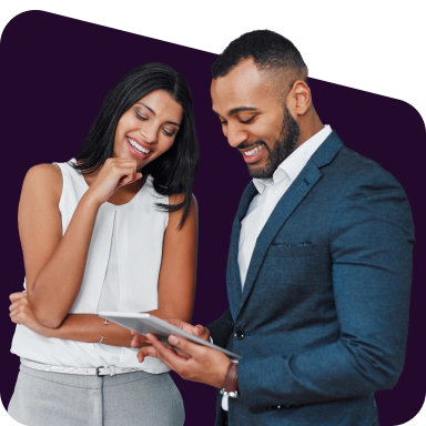 Two smiling people looking at the screen of a tablet.