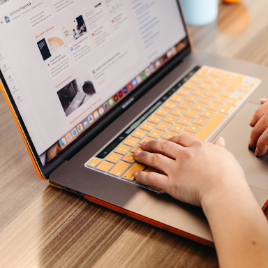 Hands typing on a computer.