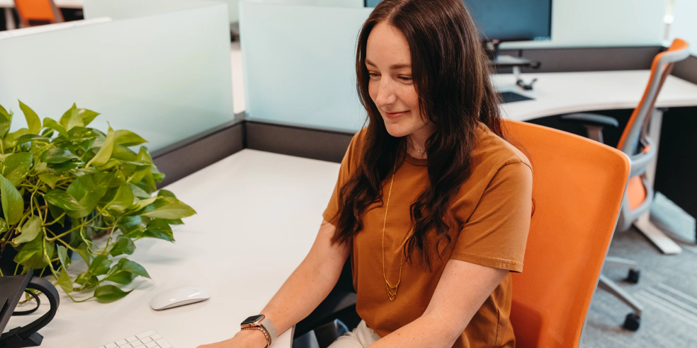 A woman sitting at her desk working on a computer.