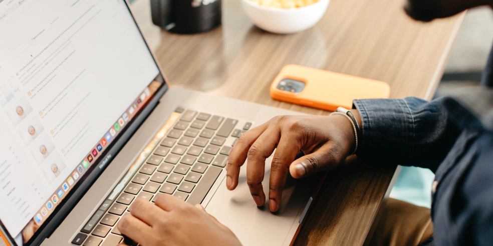 A pair of hands resting on a laptop keyboard.