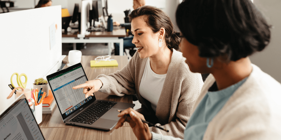 Two people looking at a laptop screen.